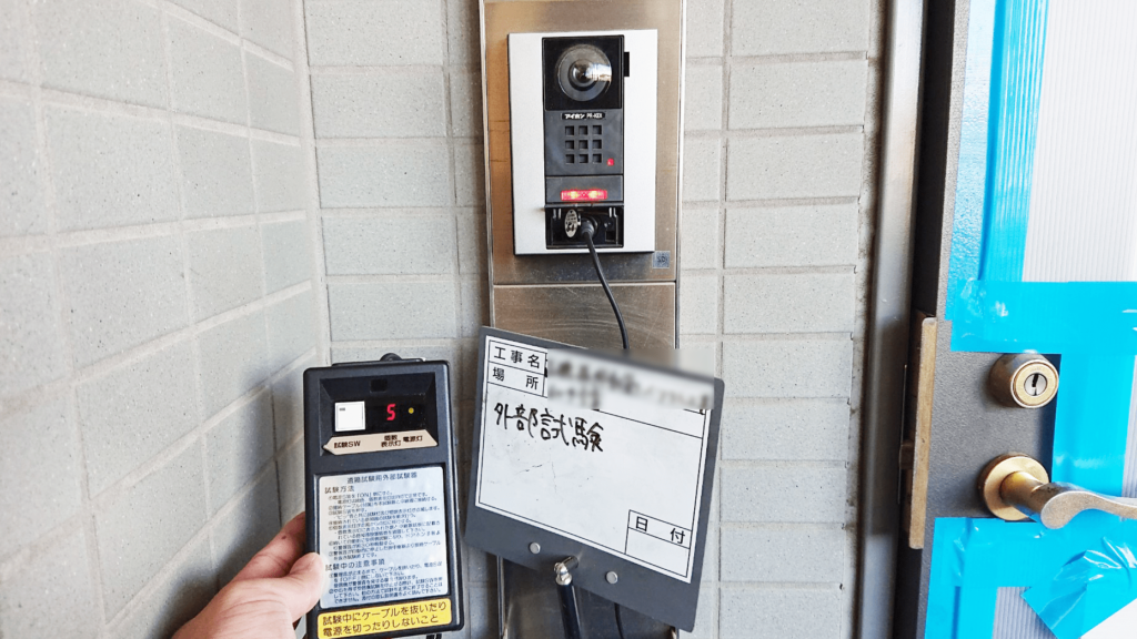 ドアホンから専用の試験器で試験中